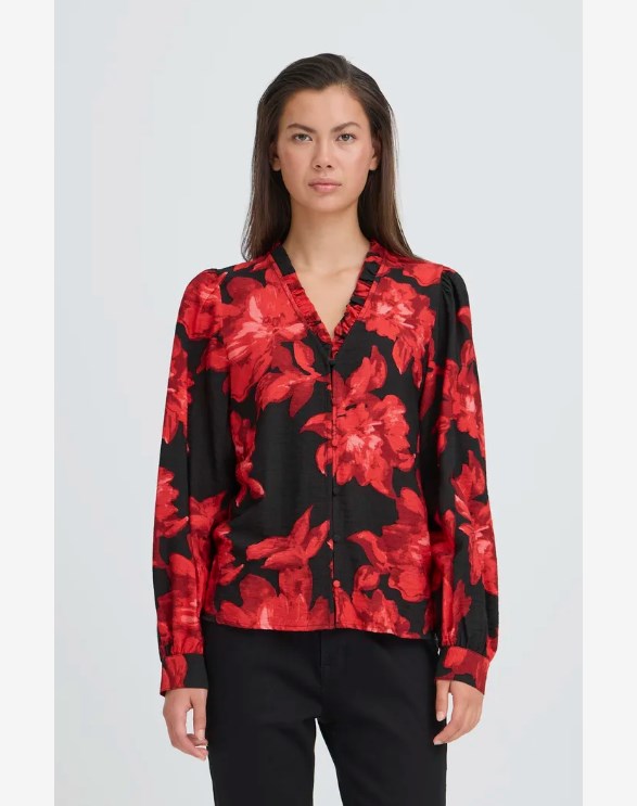 Woman wearing a red and black floral blouse against a white background
