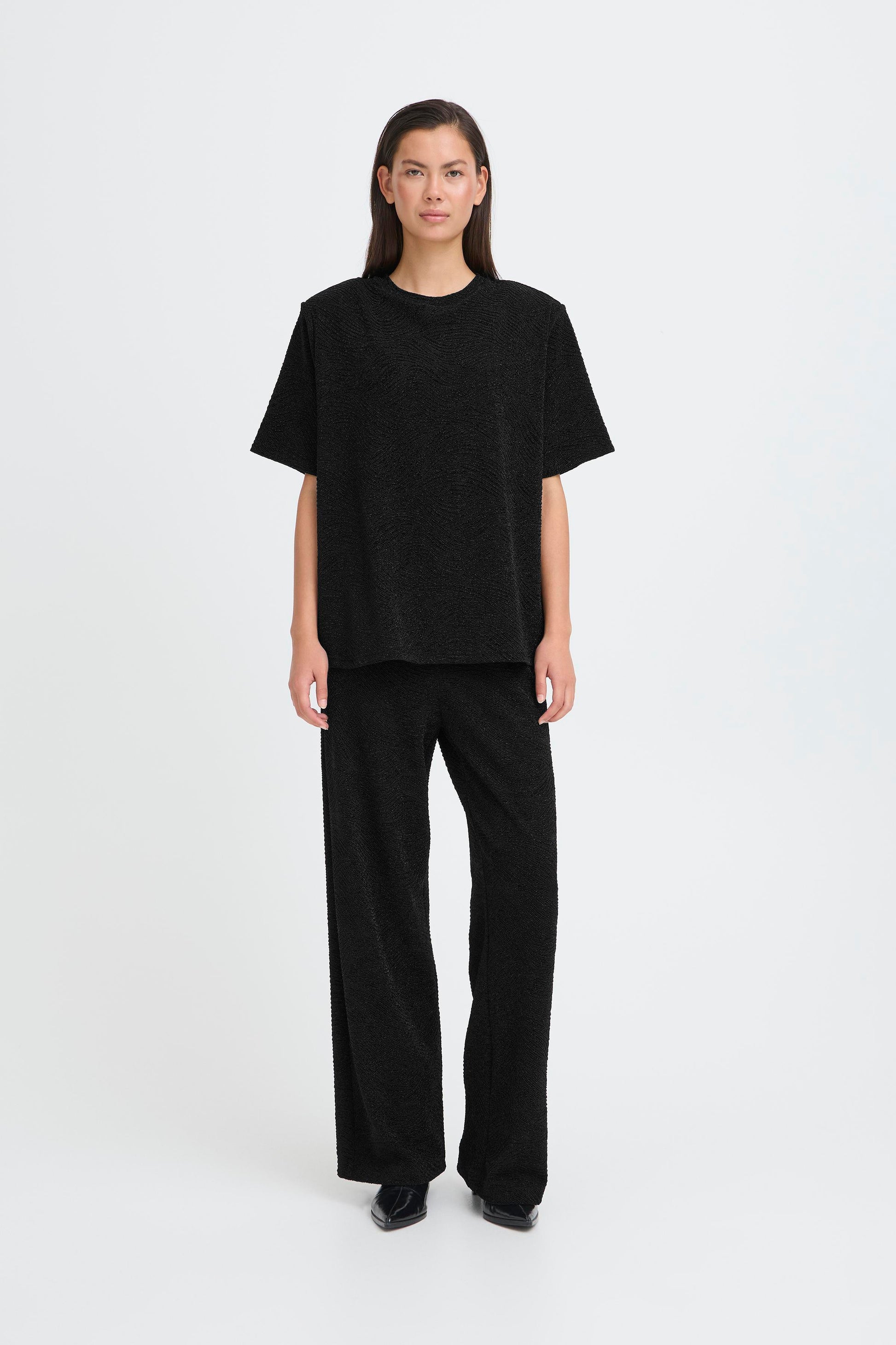 Person wearing a black outfit on a white background