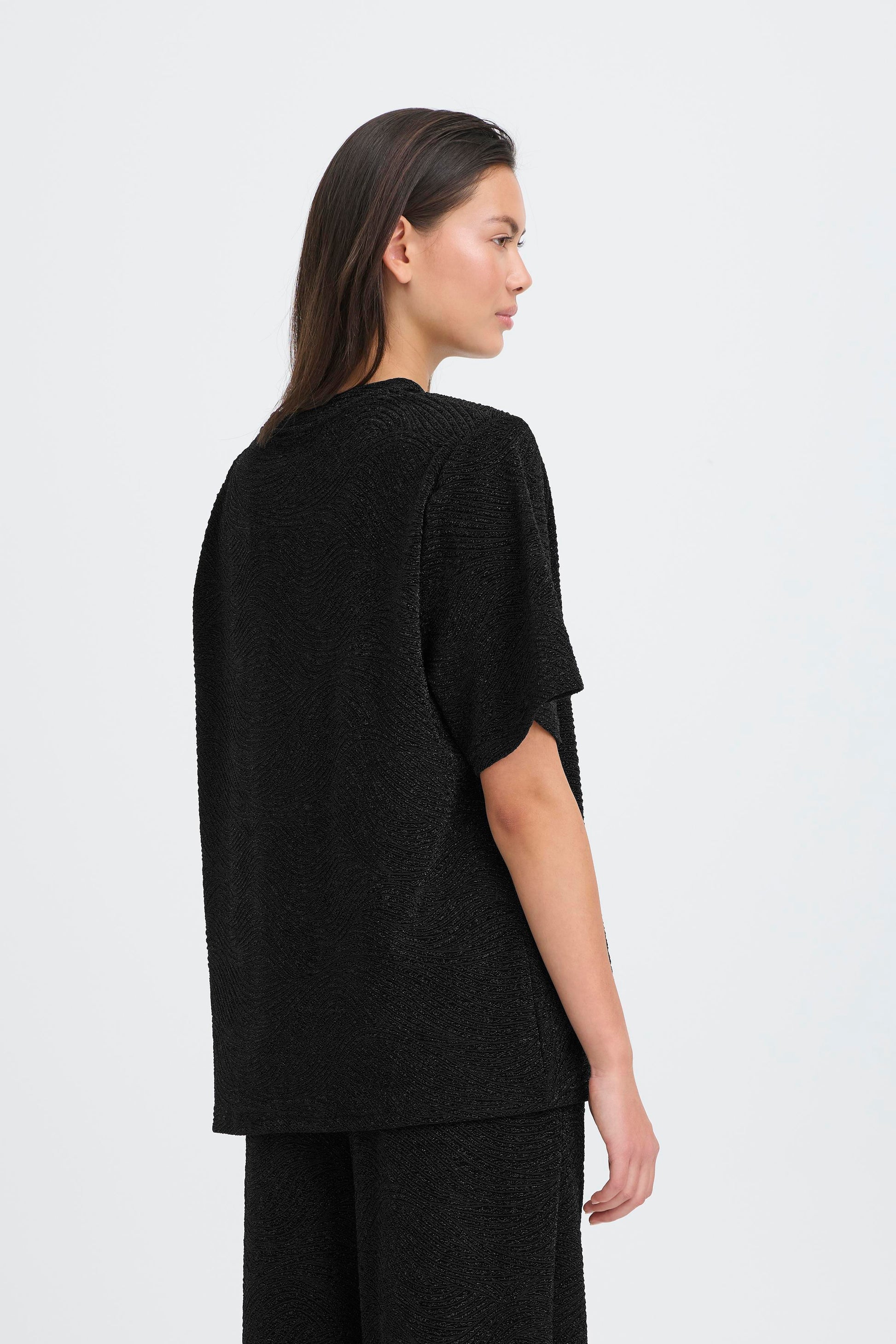 Person wearing a black outfit on a white background