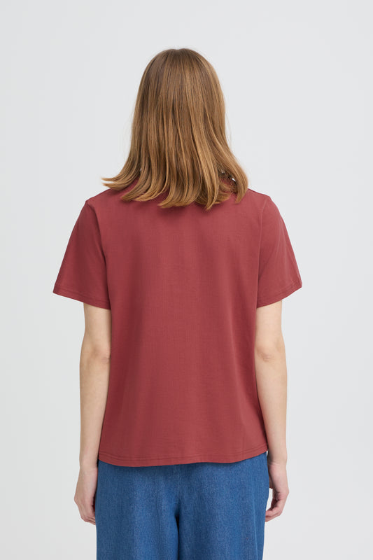 Person wearing a maroon t-shirt and blue pants on a white background