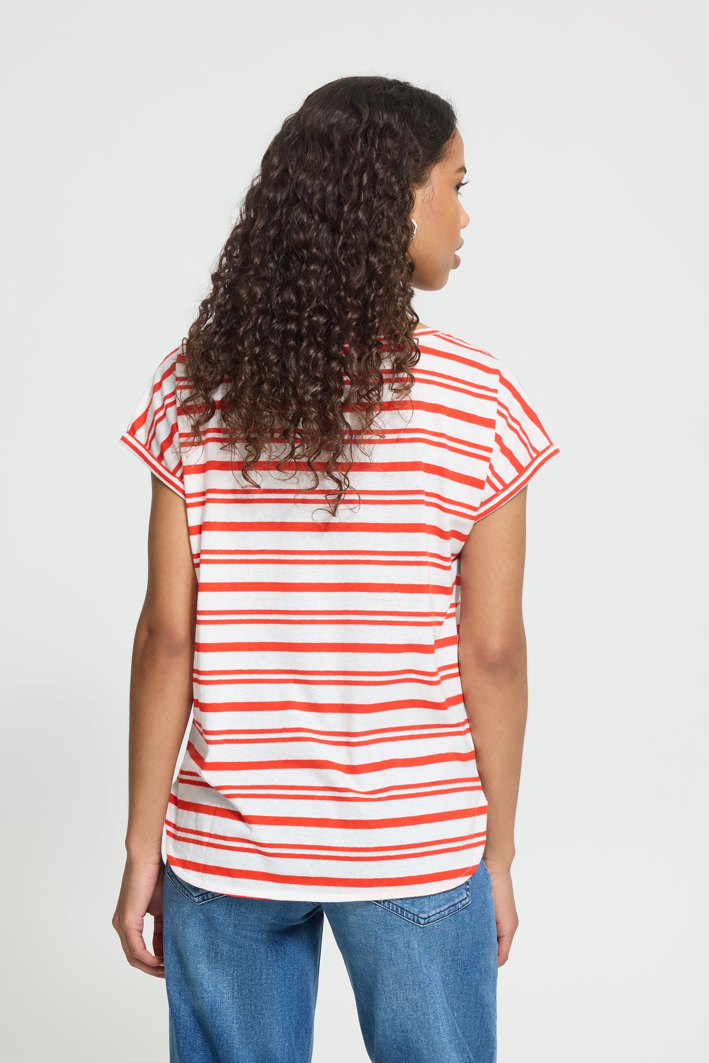 Person wearing a red and white striped shirt on a plain background