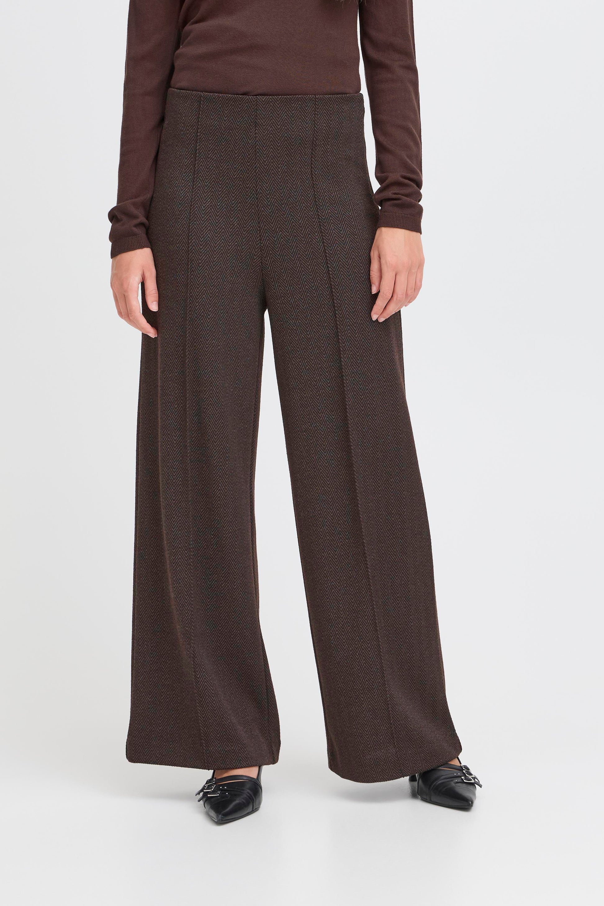 Brown wide-leg pants worn by a person on a white background