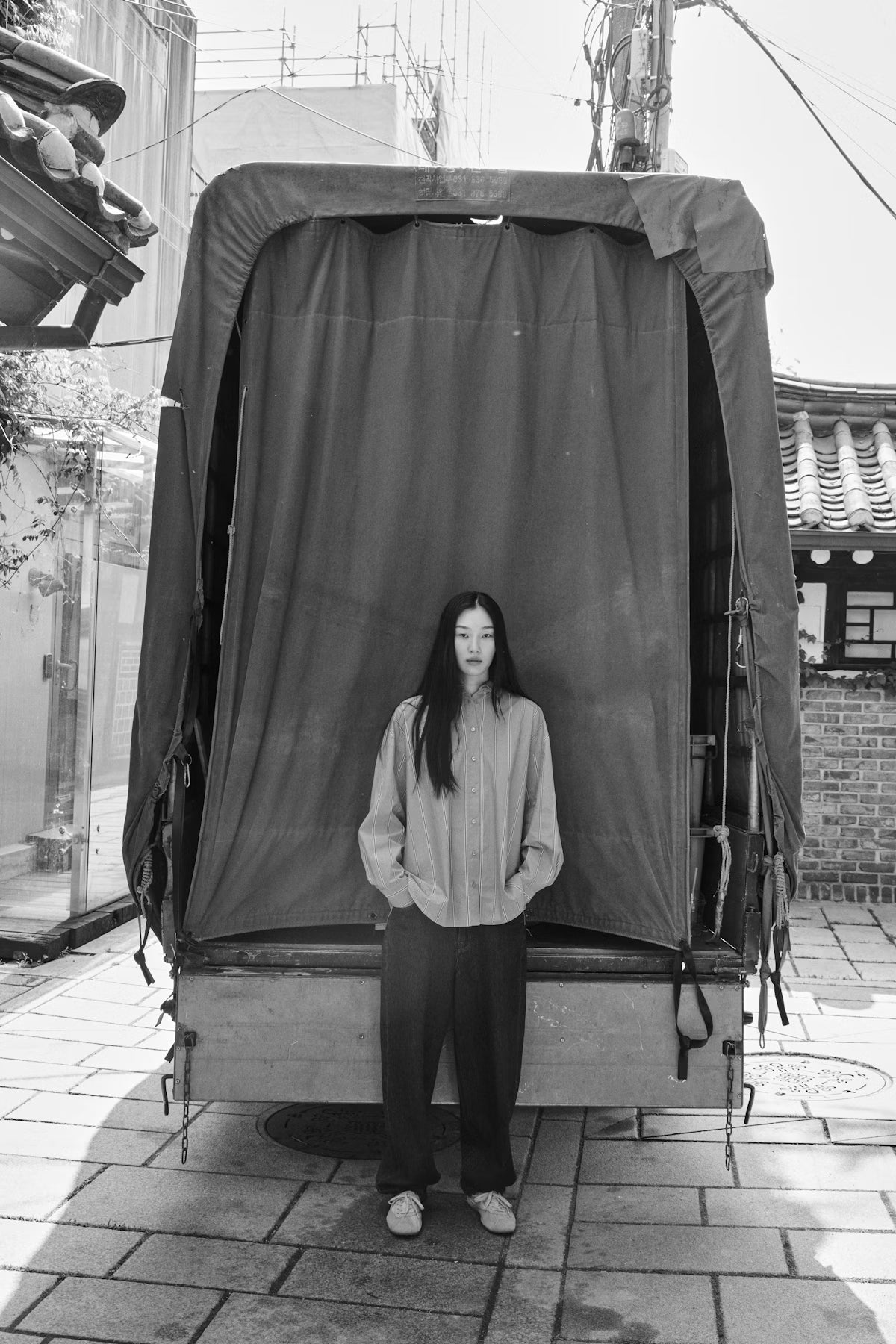 Person standing in front of a large fabric-covered object in an outdoor setting