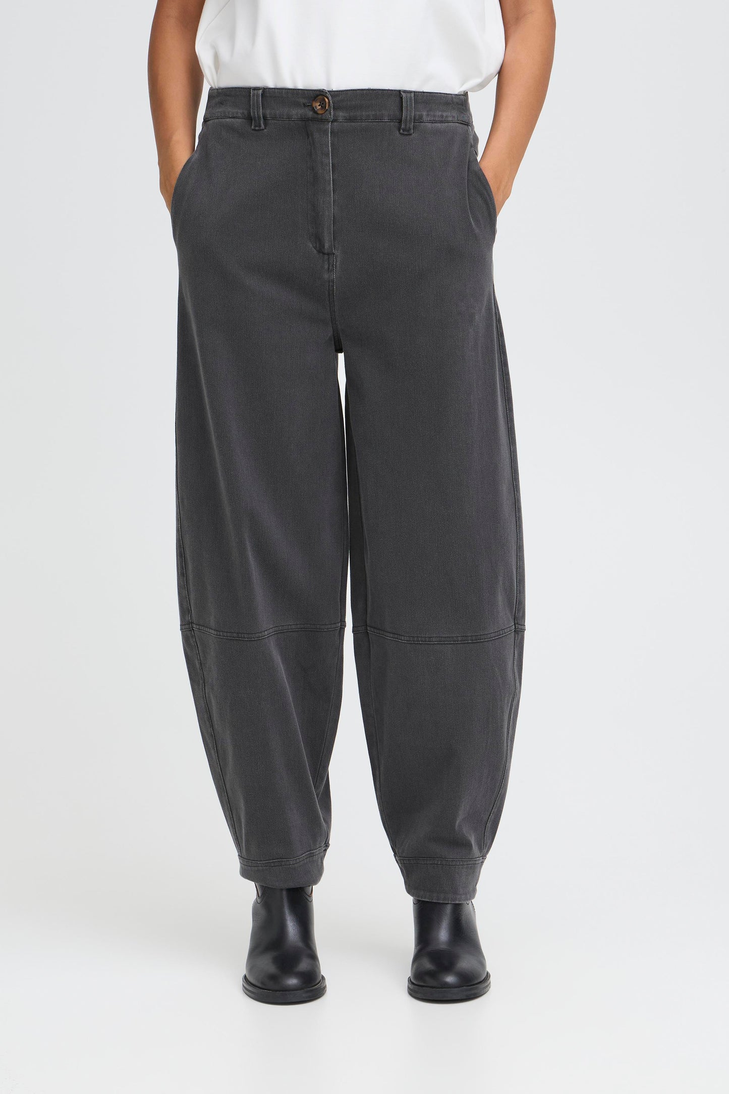 Person wearing dark gray pants on a white background