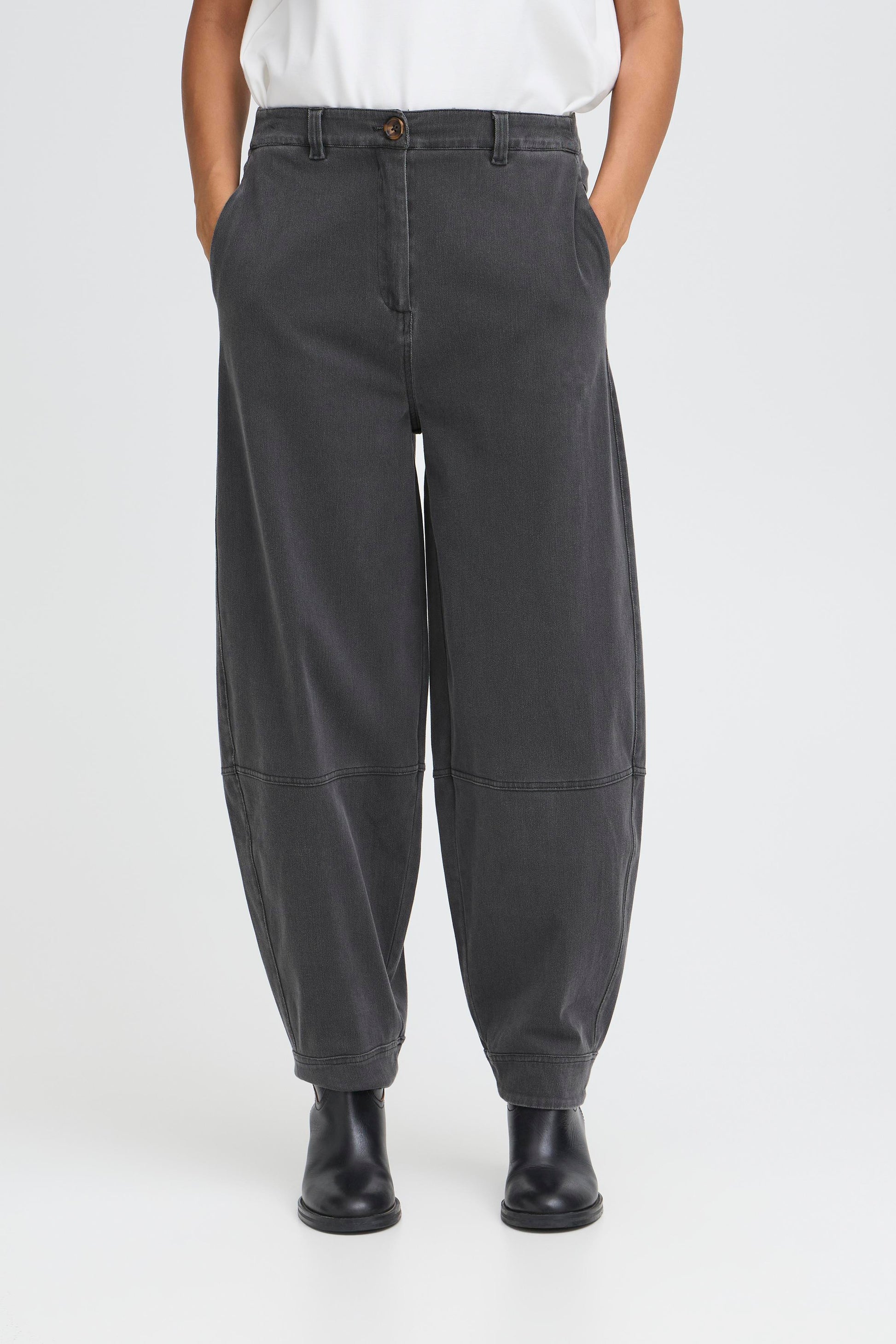 Person wearing dark gray pants on a white background
