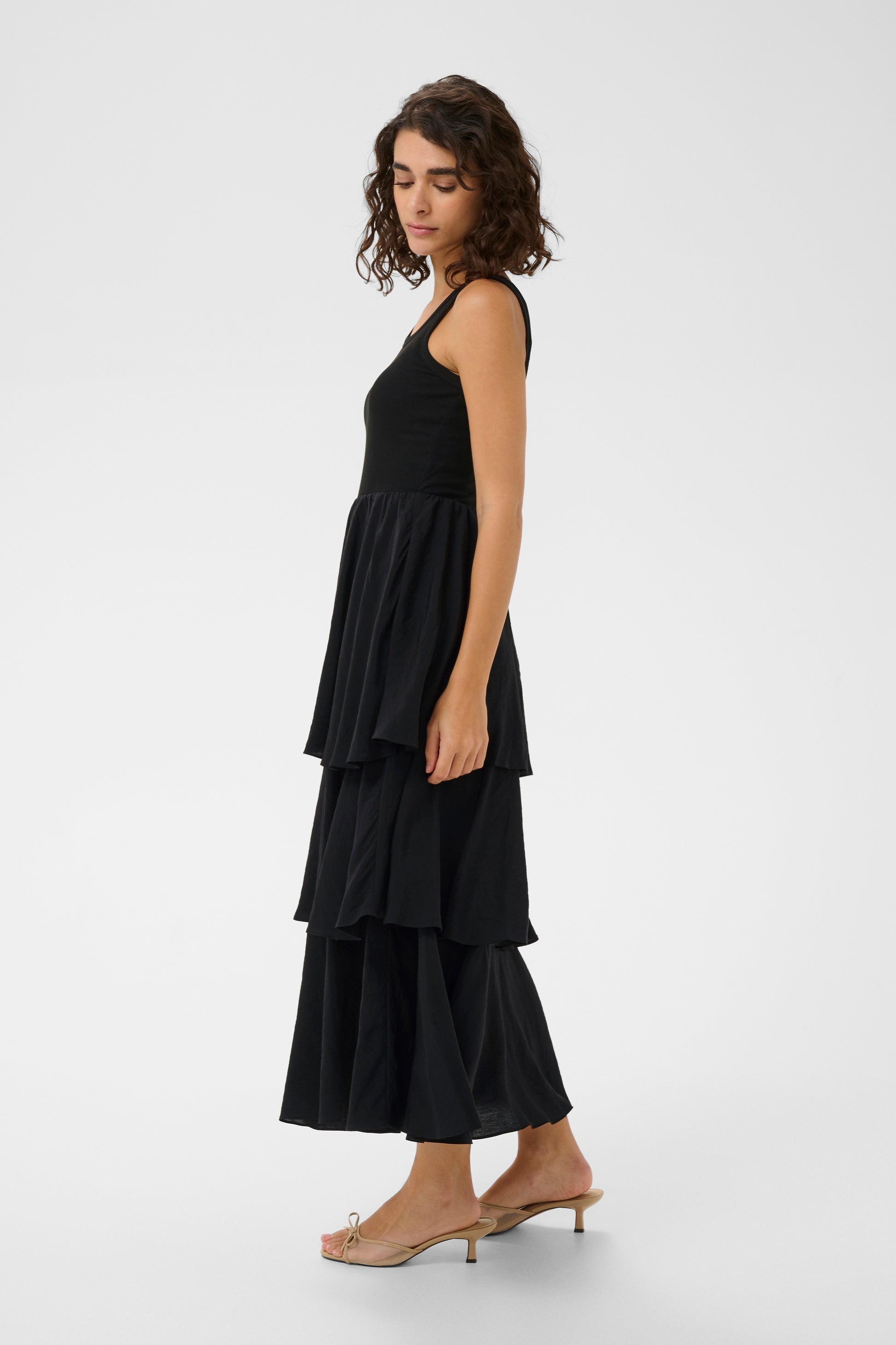 Woman wearing a black layered dress on a white background