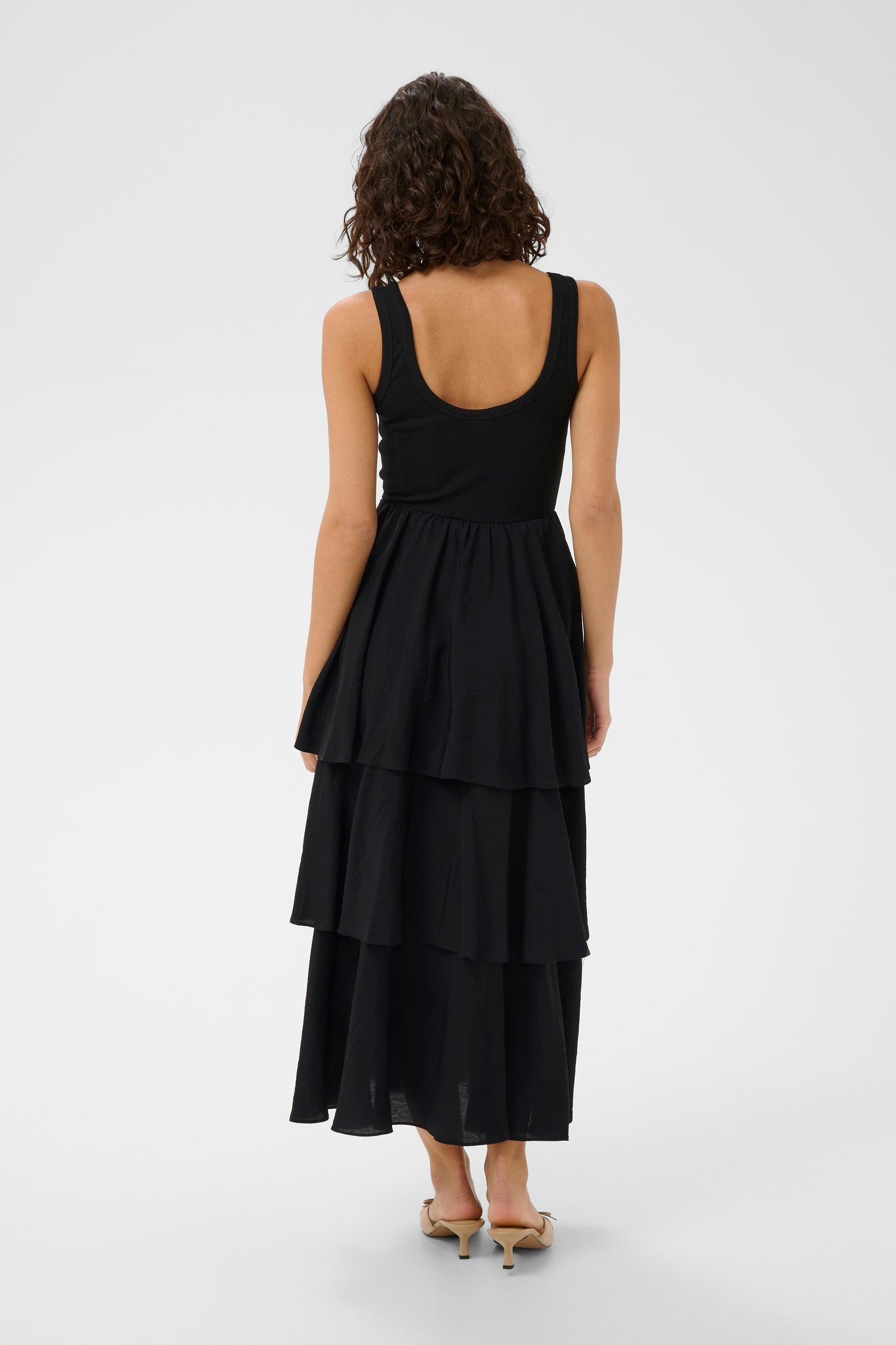Black tiered dress worn by a person on a white background