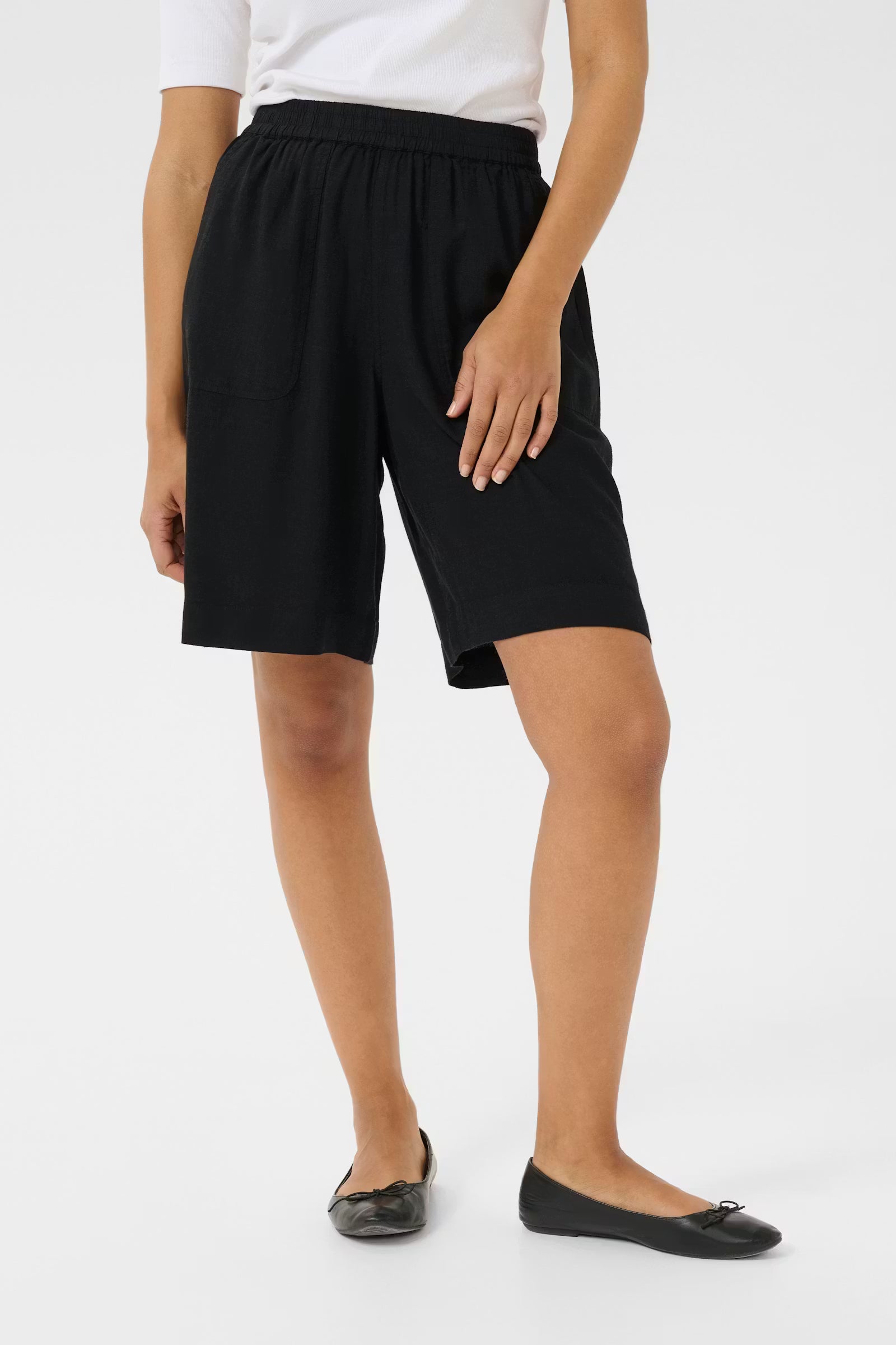 Person wearing black shorts on a white background