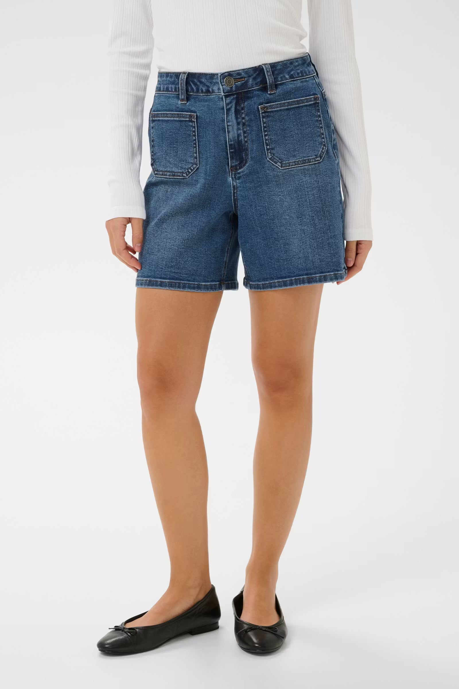 Person wearing blue denim shorts on a white background
