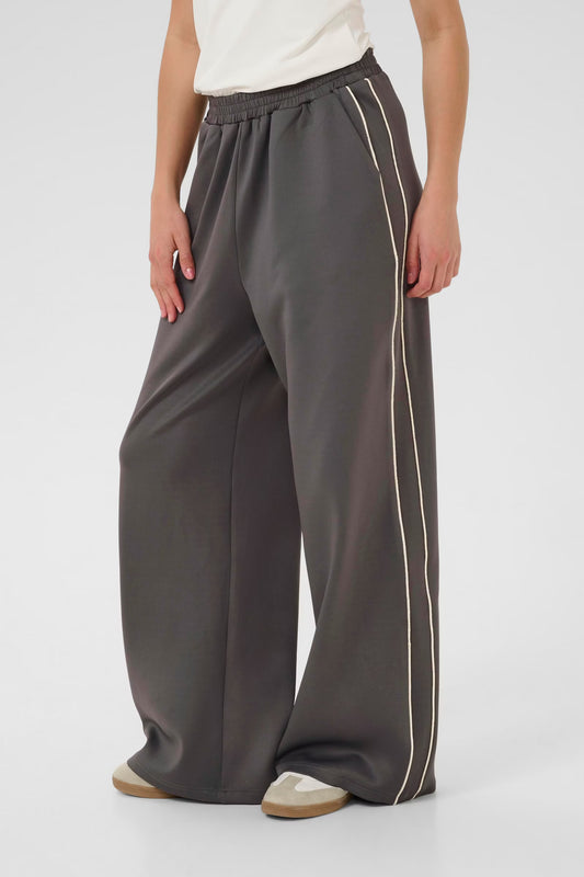 Person wearing gray wide-leg pants with a stripe on a white background