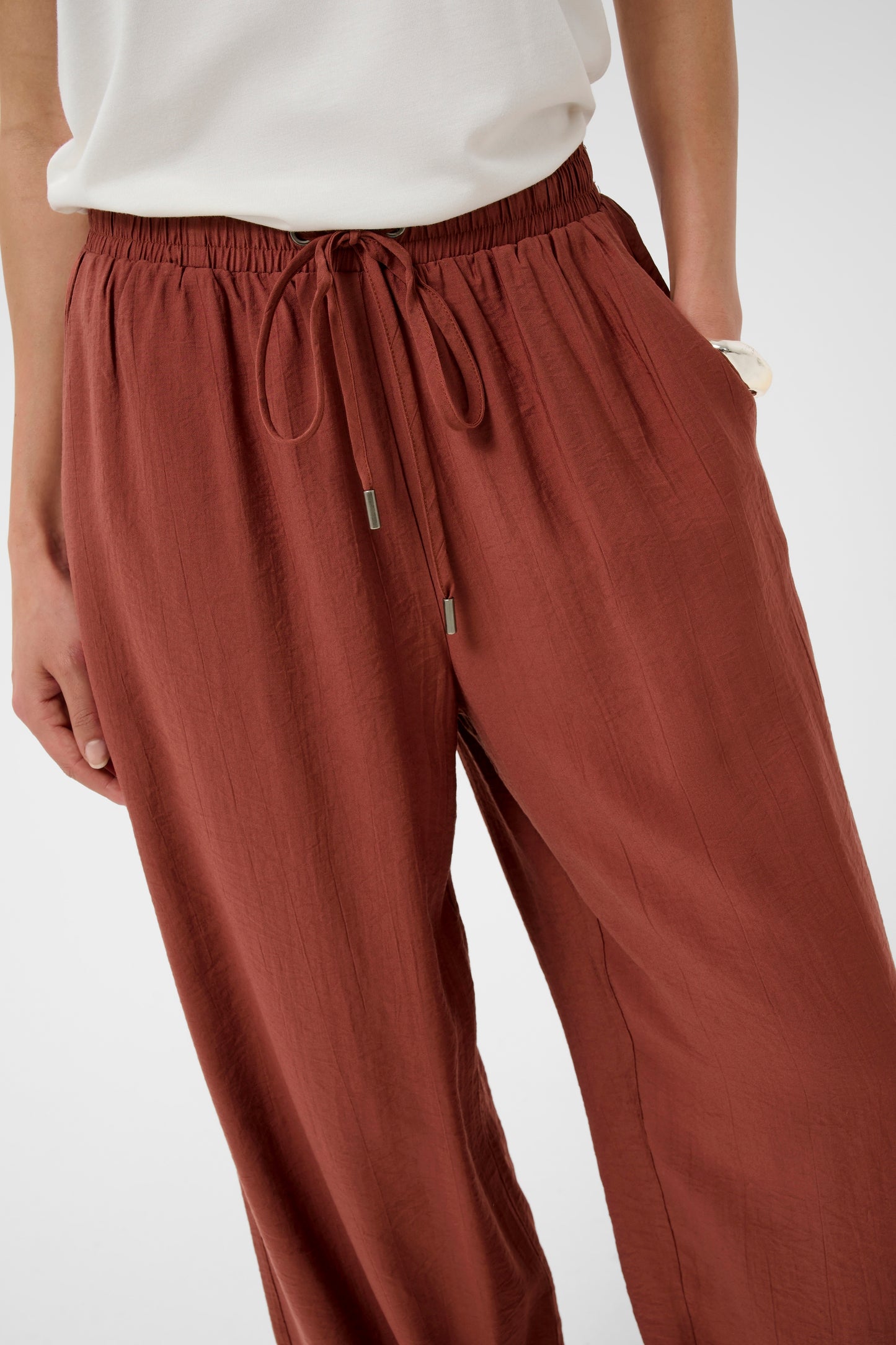 Maroon pants with drawstring waist on a white background