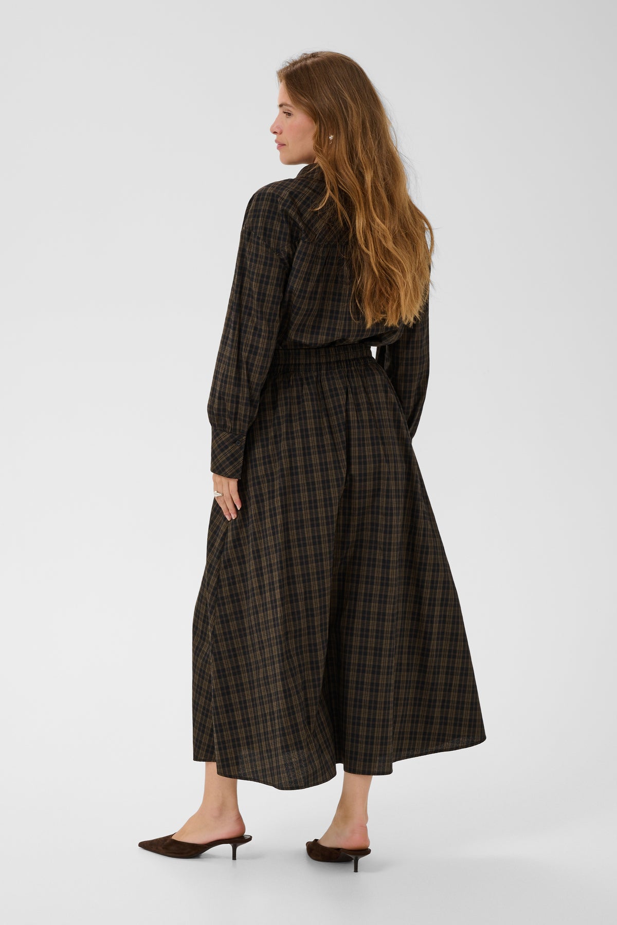 Woman wearing a plaid dress on a white background