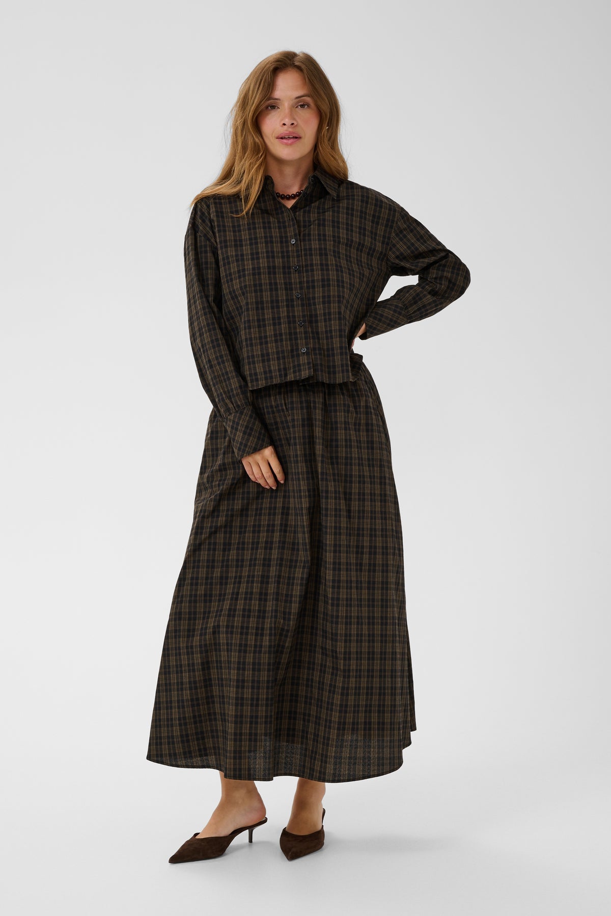 Woman wearing a plaid outfit on a white background