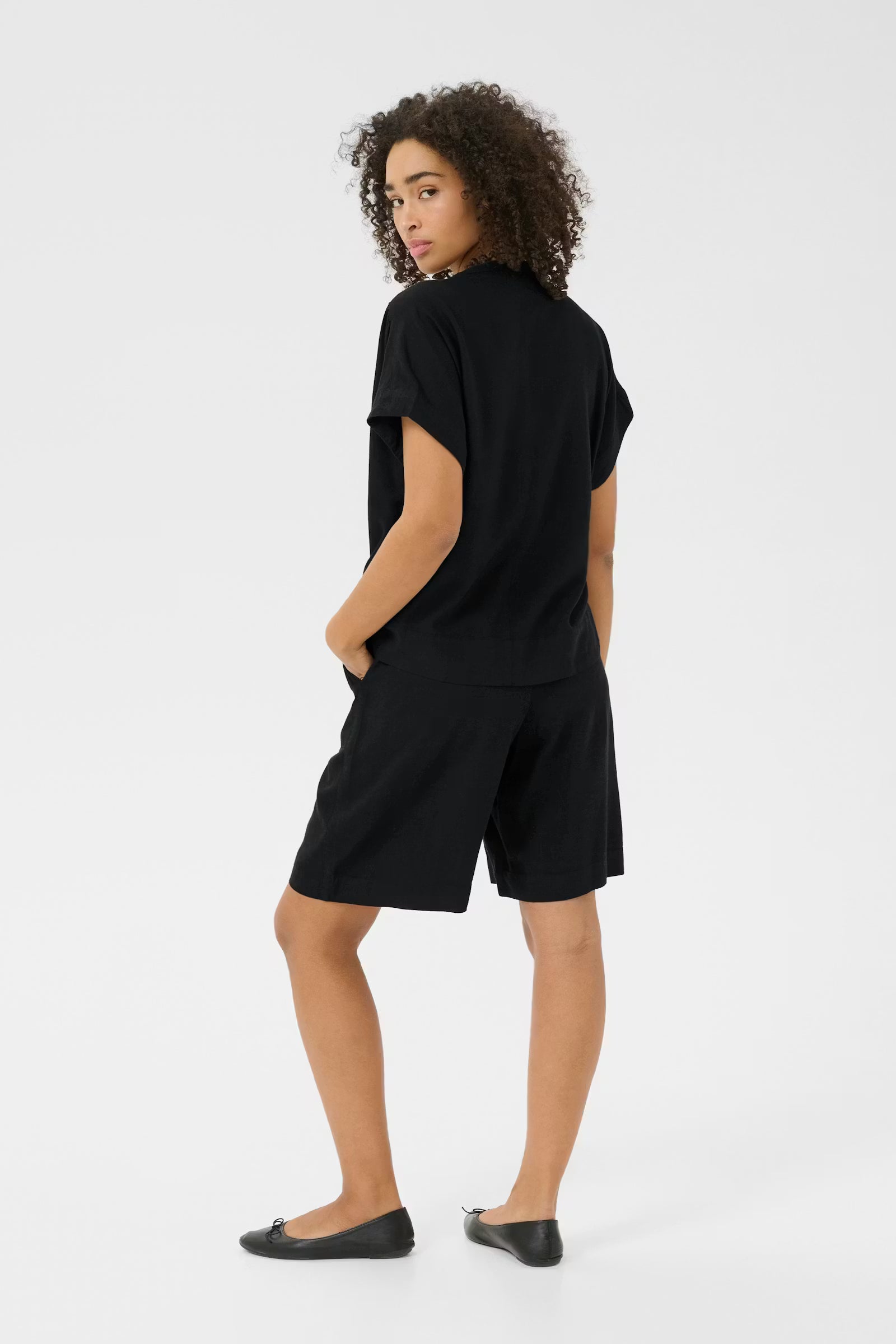 Person wearing a black outfit on a white background