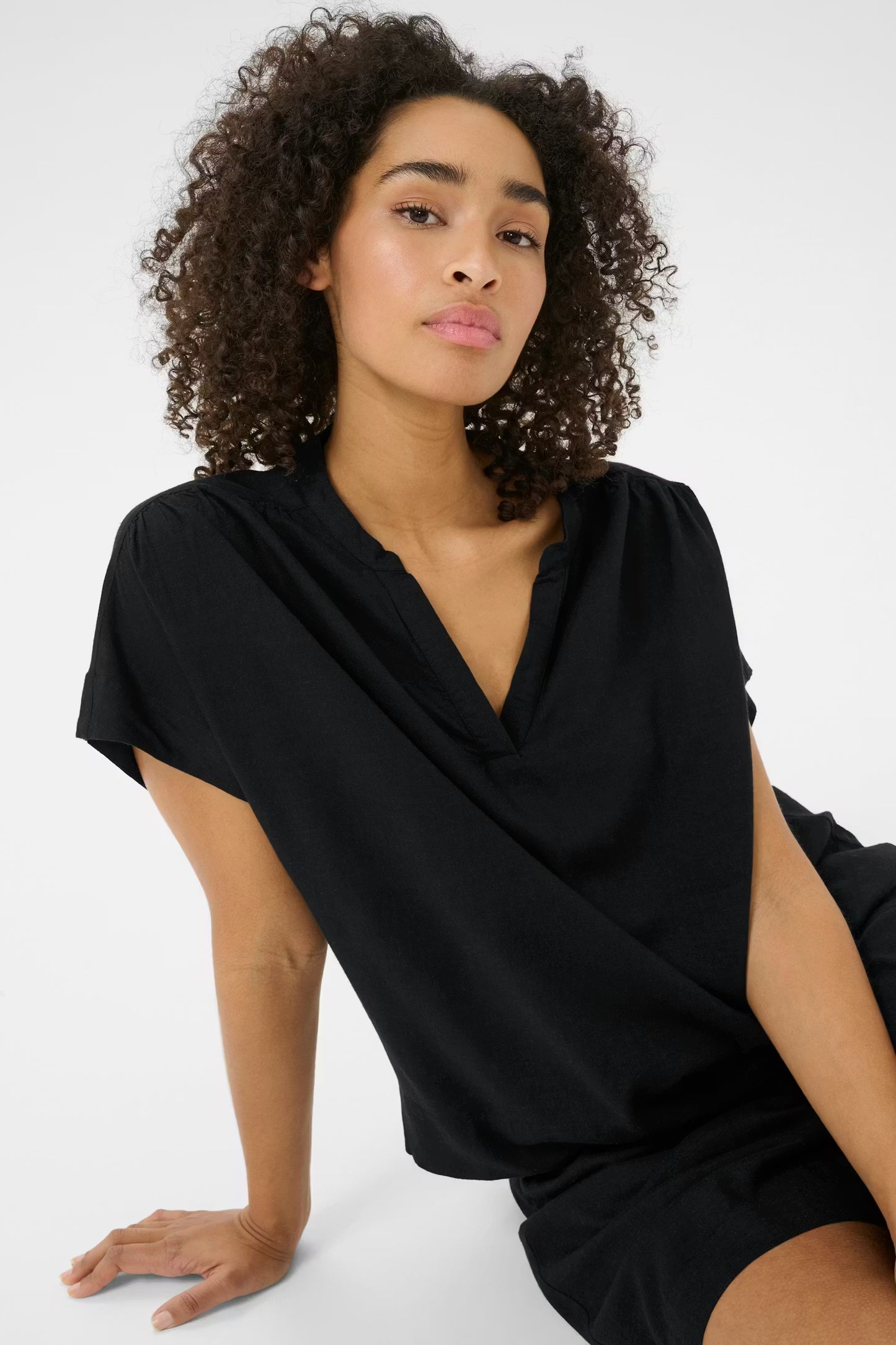 Woman wearing a black dress against a white background