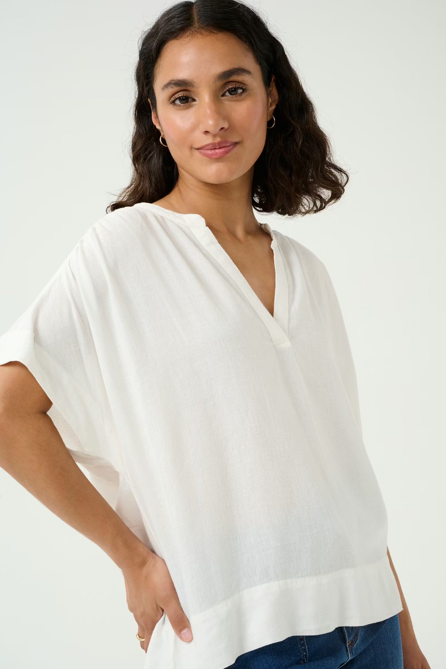 Woman wearing a white blouse against a plain background