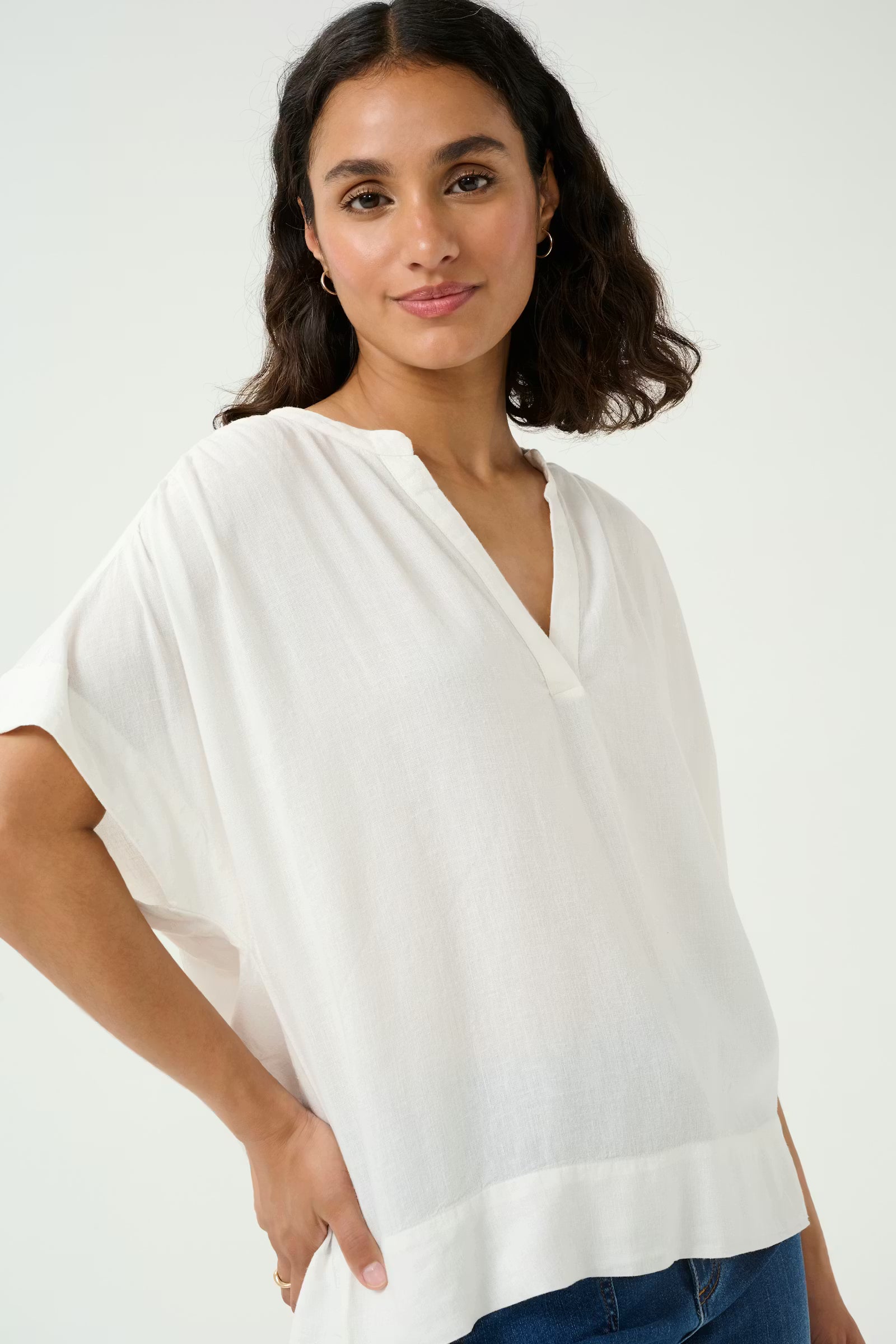 Woman wearing a white blouse against a plain background