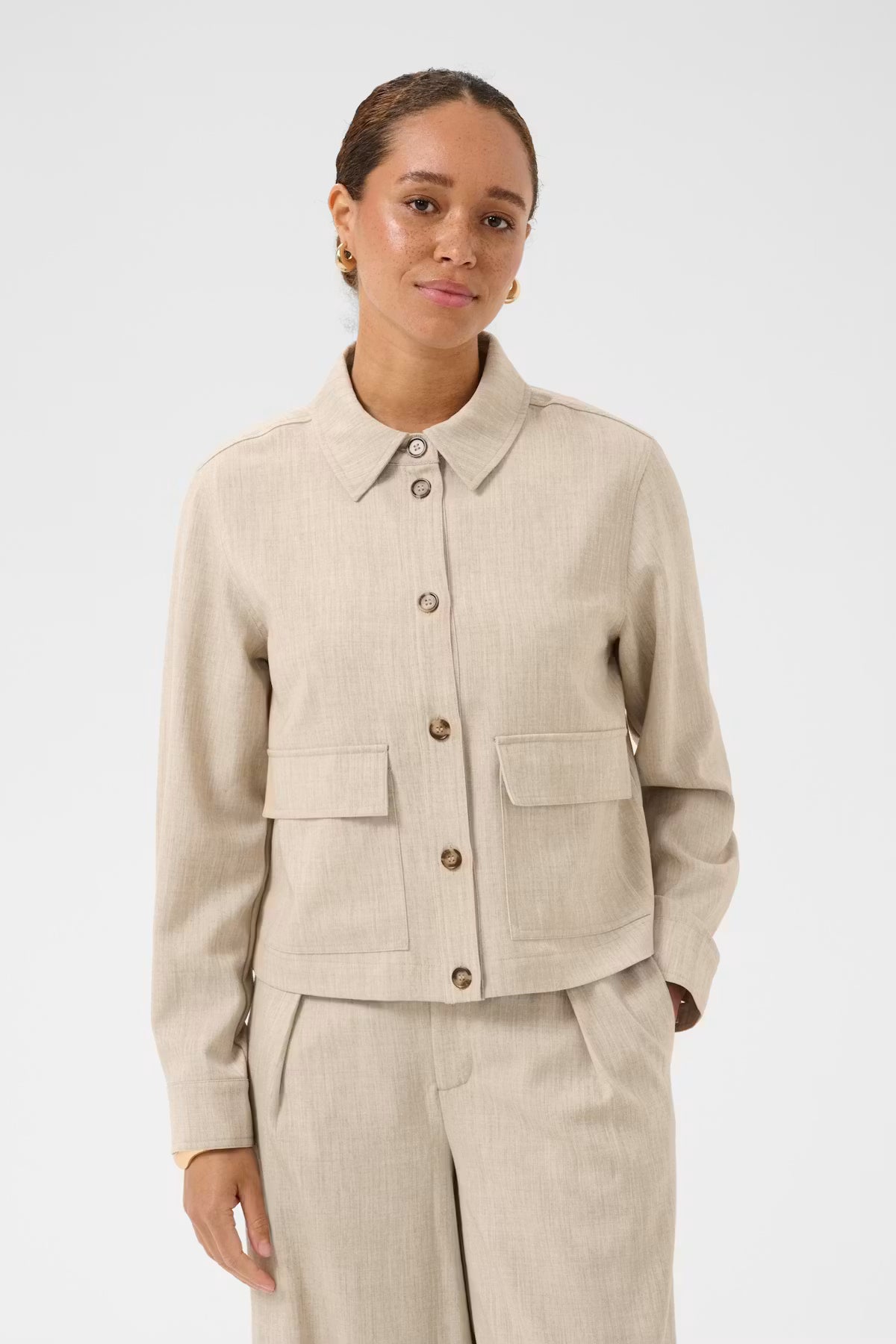 woman wearing a beige jacket on white background