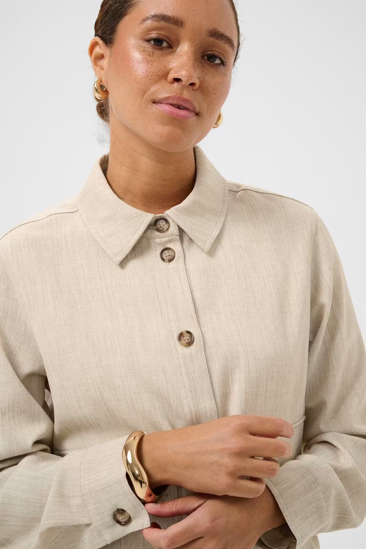 woman wearing a beige outfit on a white background