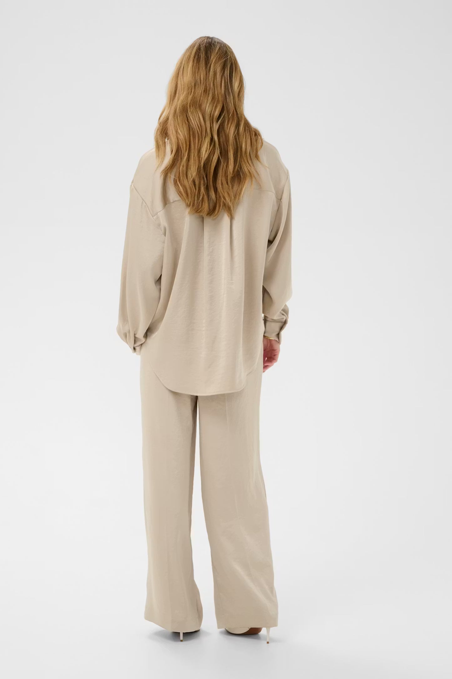 Person wearing a beige outfit on a white background