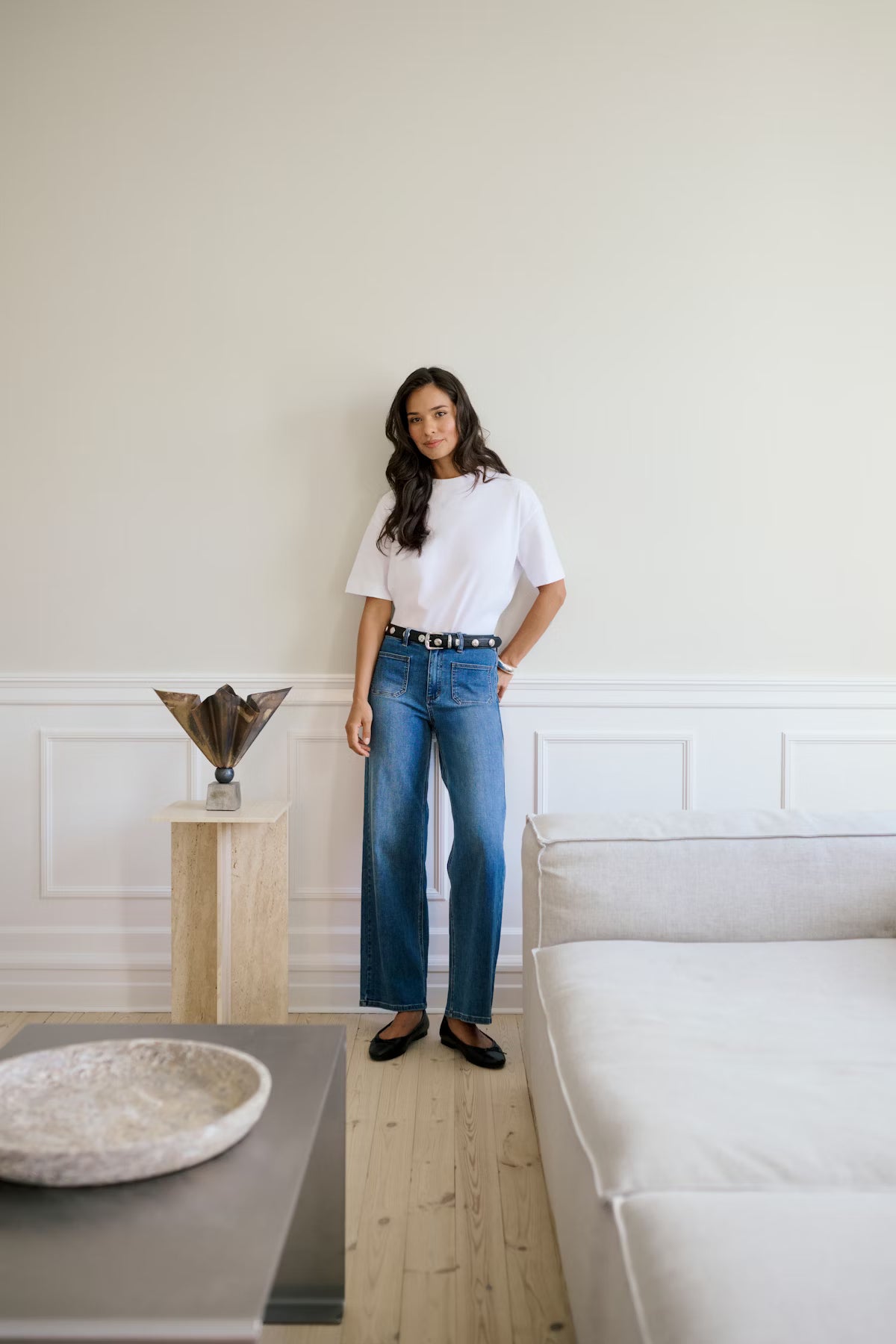 Woman standing in a modern living room with a neutral color palette
