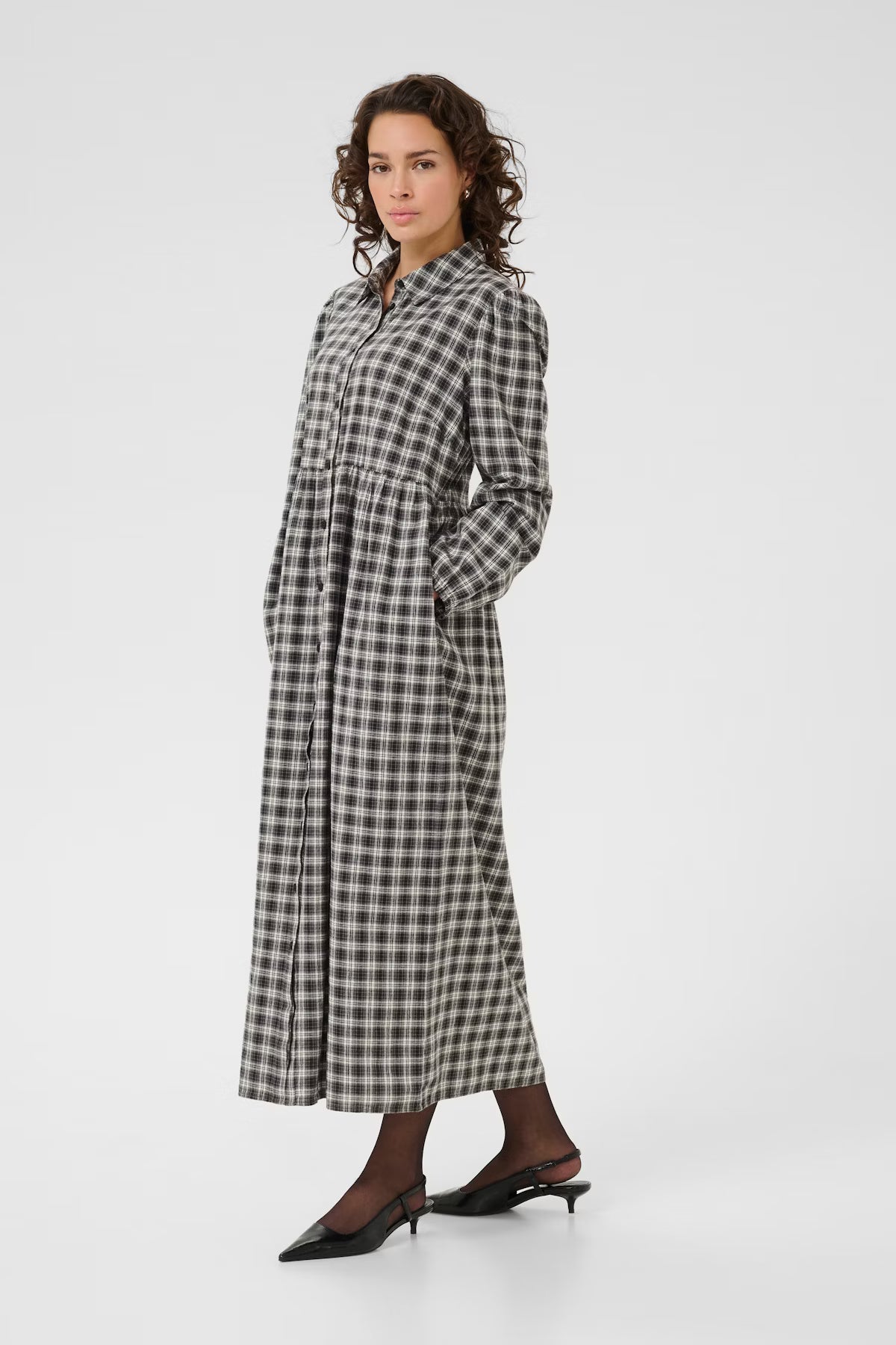 Woman wearing a checkered dress on a white background