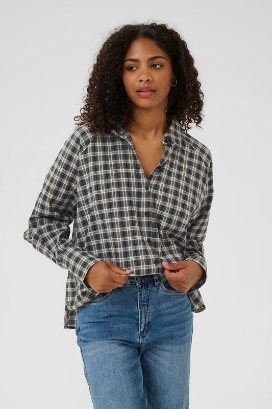 Woman wearing a plaid shirt and blue jeans on a white background