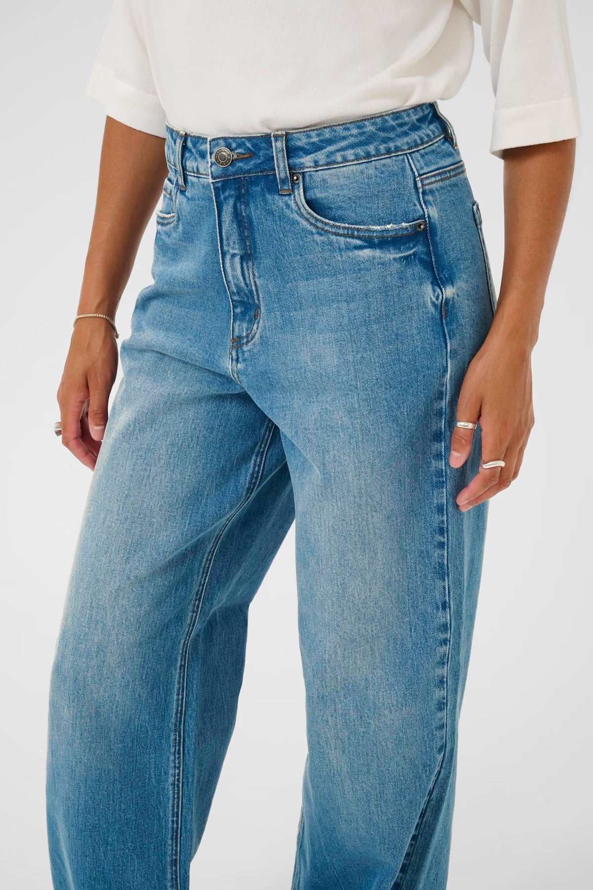 Person wearing blue jeans on a white background