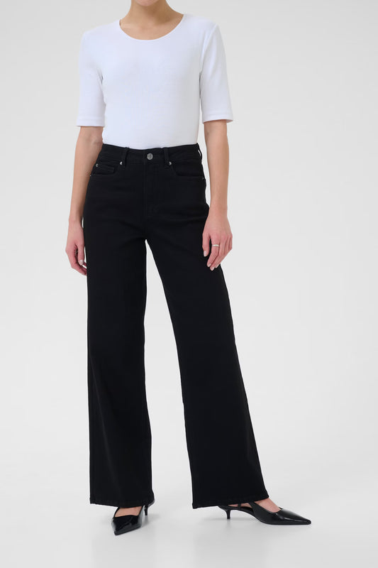 Person wearing a white top and black jeans on a white background