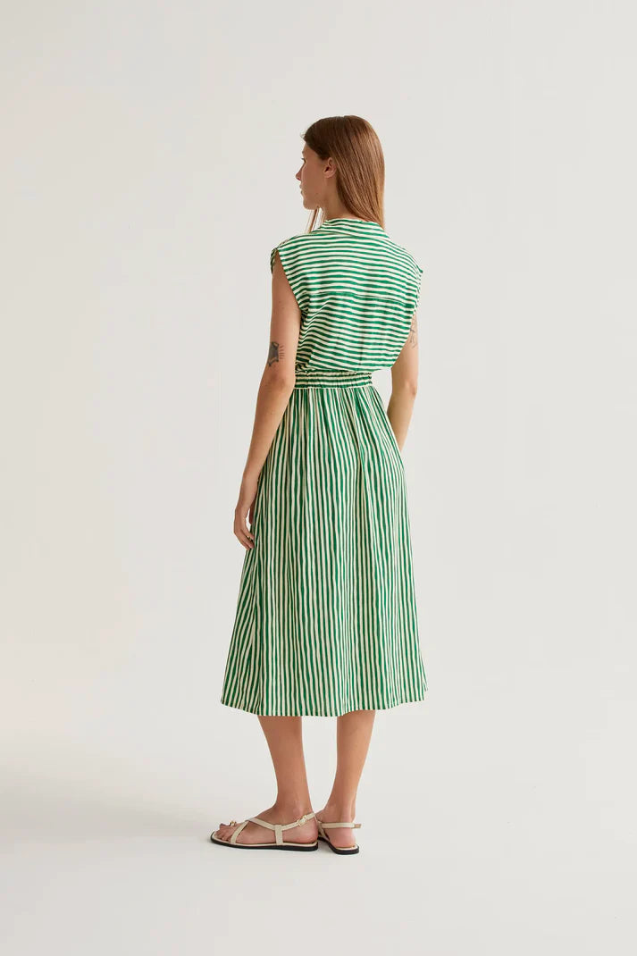Woman wearing a green and white striped dress on a white background