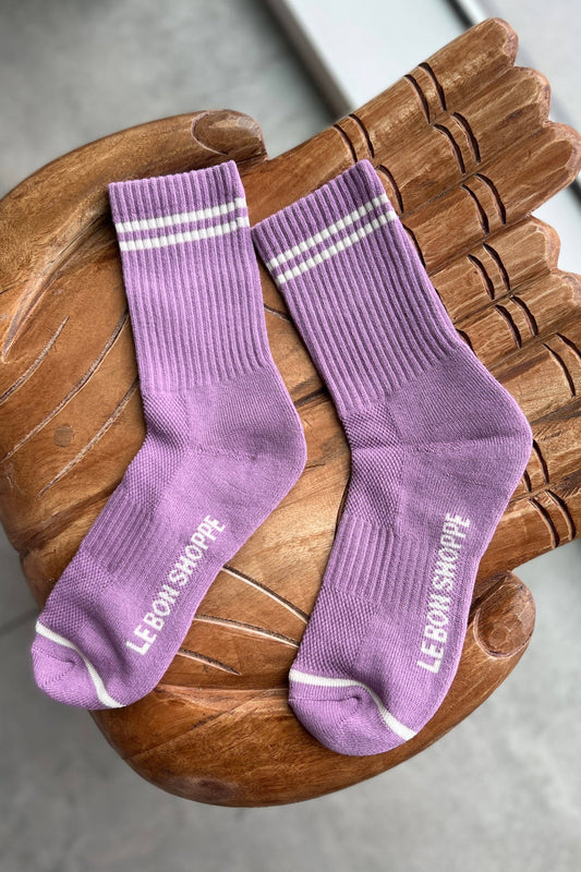 Pair of purple socks with white stripes on a wooden chair