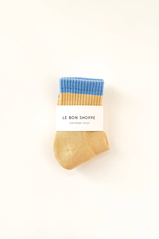 Pair of blue and beige socks with 'Le Bon Shoppe' label on a white background
