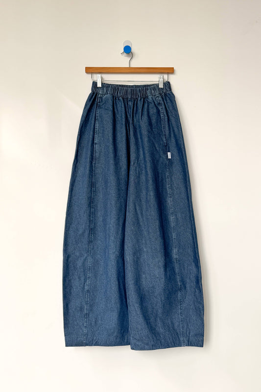 Blue denim wide-leg pants on a hanger against a white background