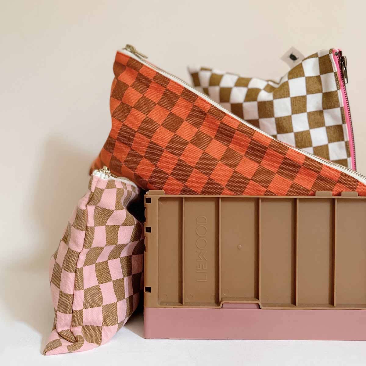 Checkered bags and a pink container with 'Klean Kanteen' branding on a light background
