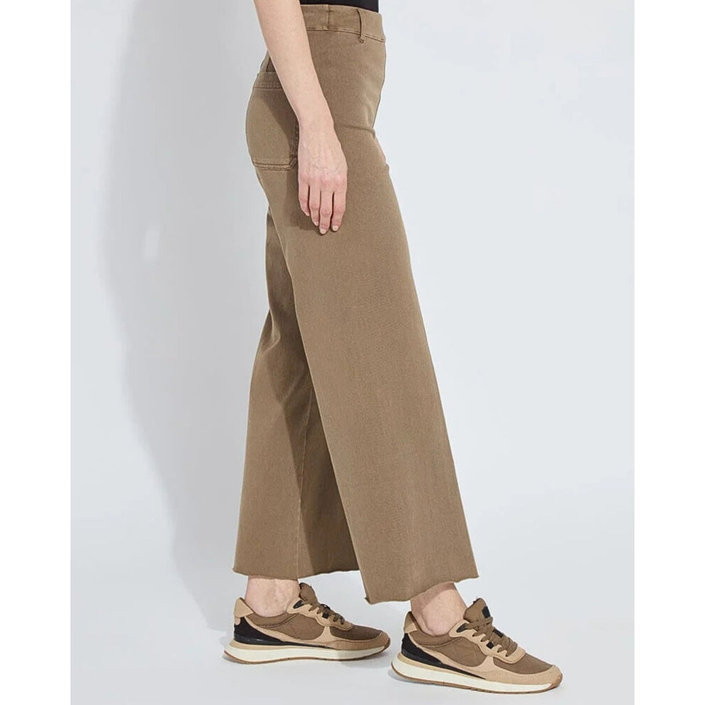 Person wearing brown wide-leg pants and matching sneakers on a white background