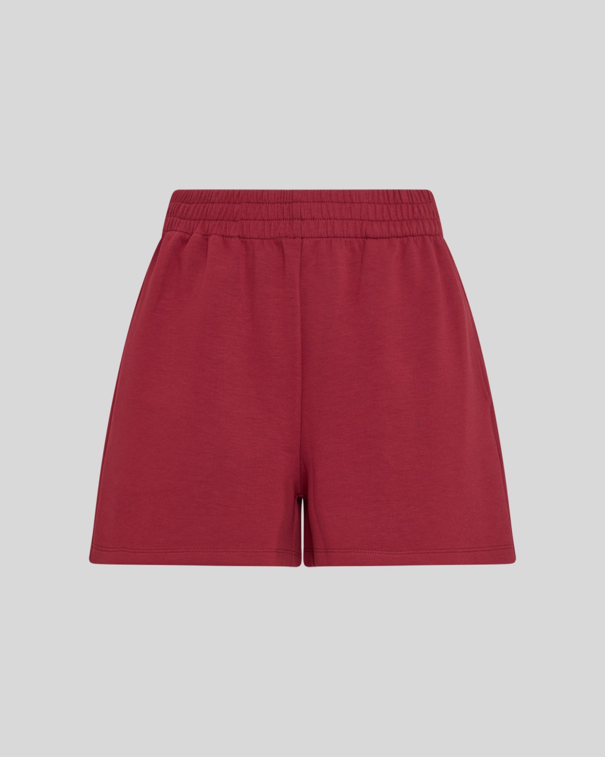Red sweat shorts on a neutral background