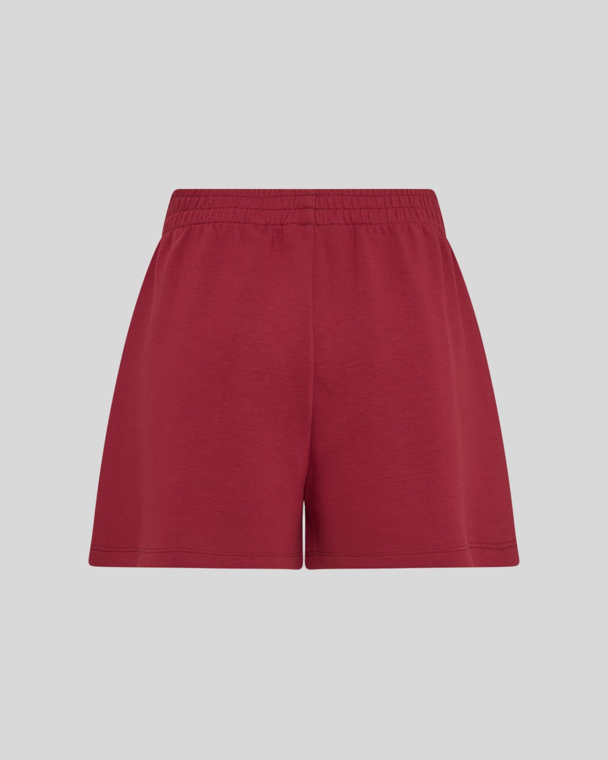 Red sweat shorts on a neutral background
