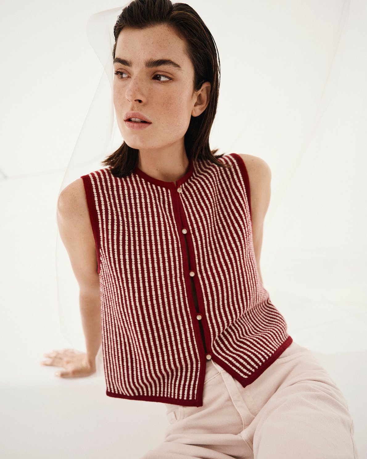 Woman wearing Red and white checkered vest and white skirt