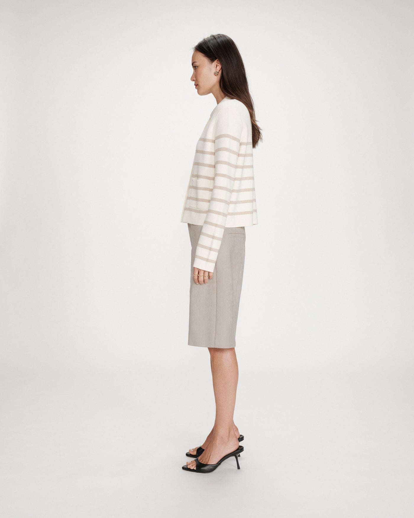 Woman wearing a striped sweater and skirt on a white background