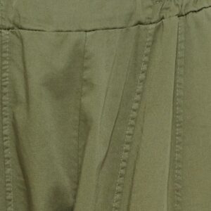 Close-up of olive green fabric with visible stitching and a gathered waistband detail.