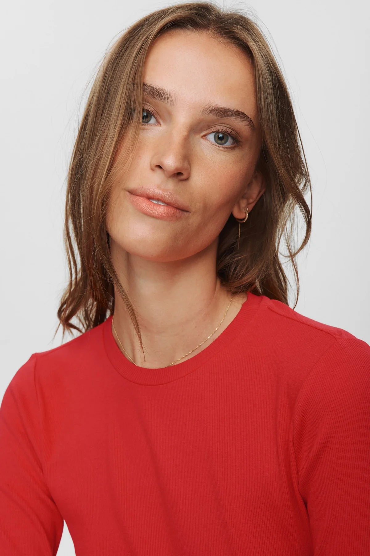 Woman wearing a red shirt against a plain background