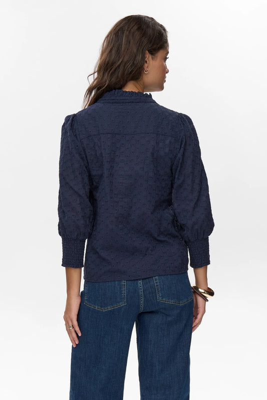 Woman wearing a navy blue shirt and jeans on a white background