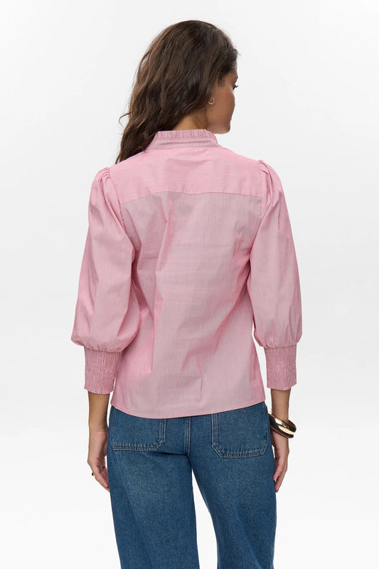 Woman wearing a pink shirt and blue jeans on a white background