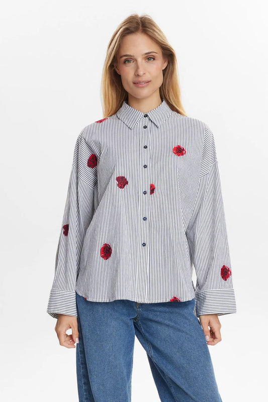 Woman wearing a stripe shirt with red floral patterns on a white background