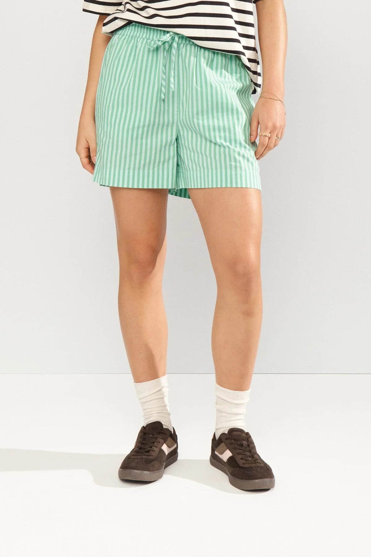 Person wearing green striped shorts on a white background
