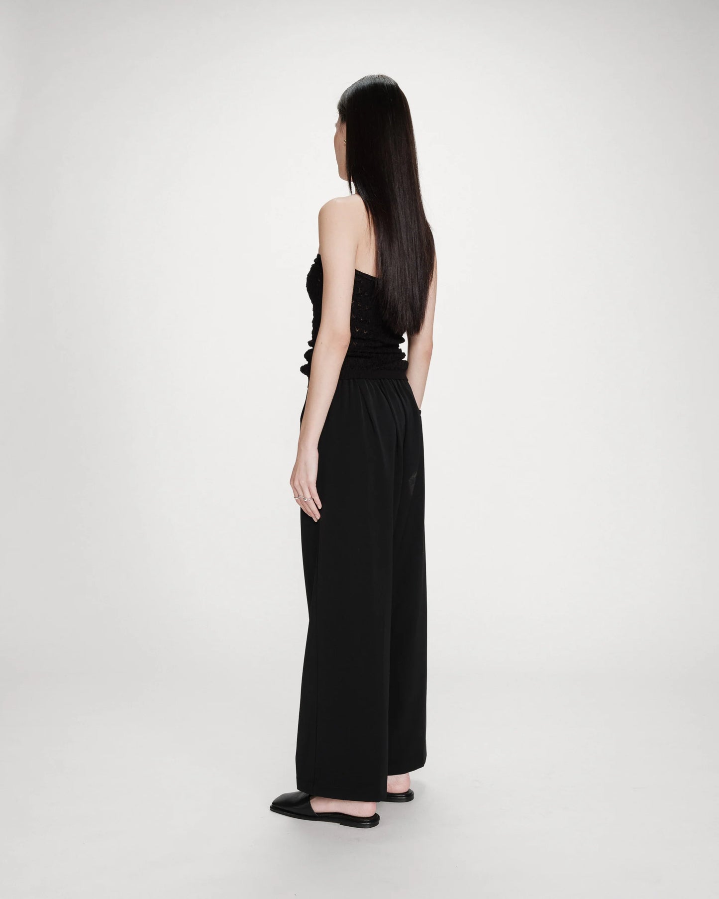 Woman wearing a black dress against a white background
