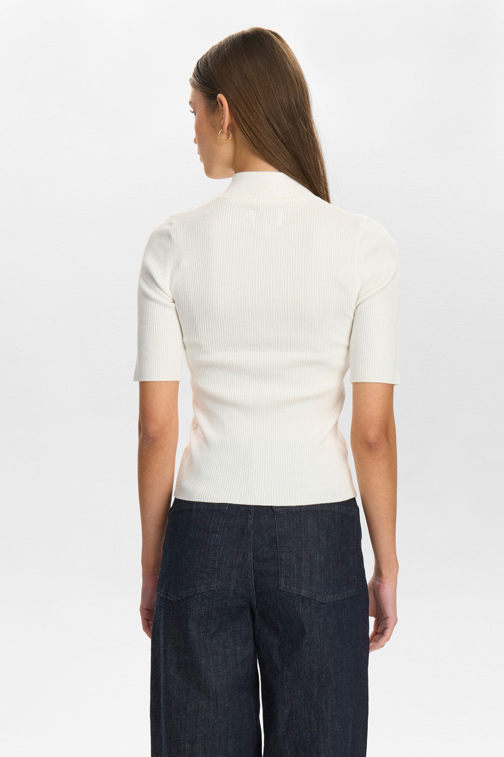 Person wearing a white short-sleeve shirt and dark pants on a white background