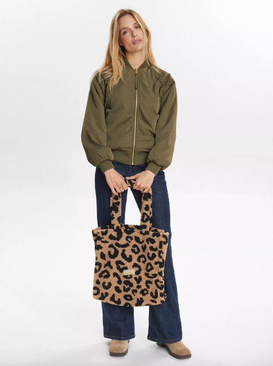 Woman holding a leopard print tote bag against a white background