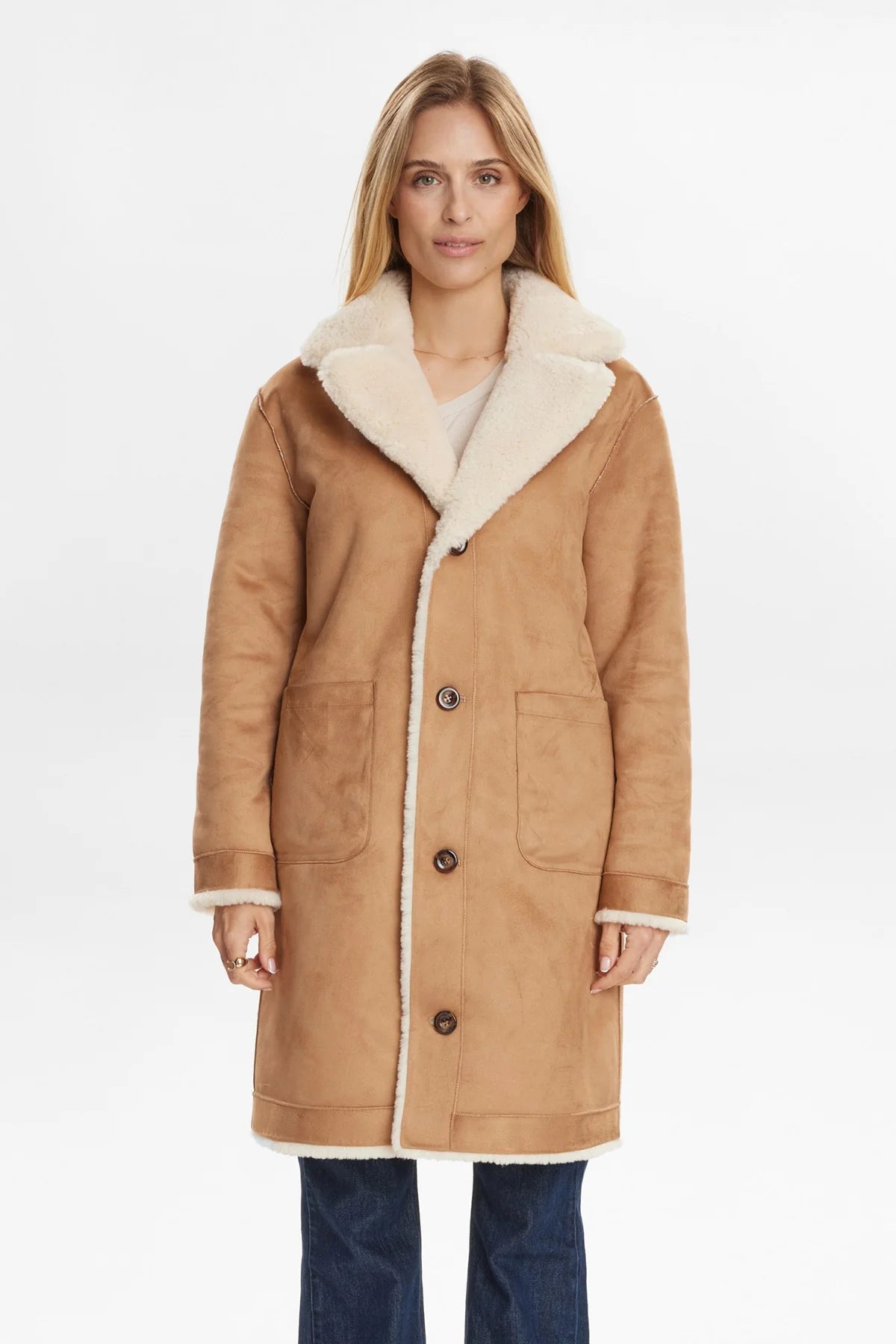 Woman wearing a tan coat with white fur lining on a white background