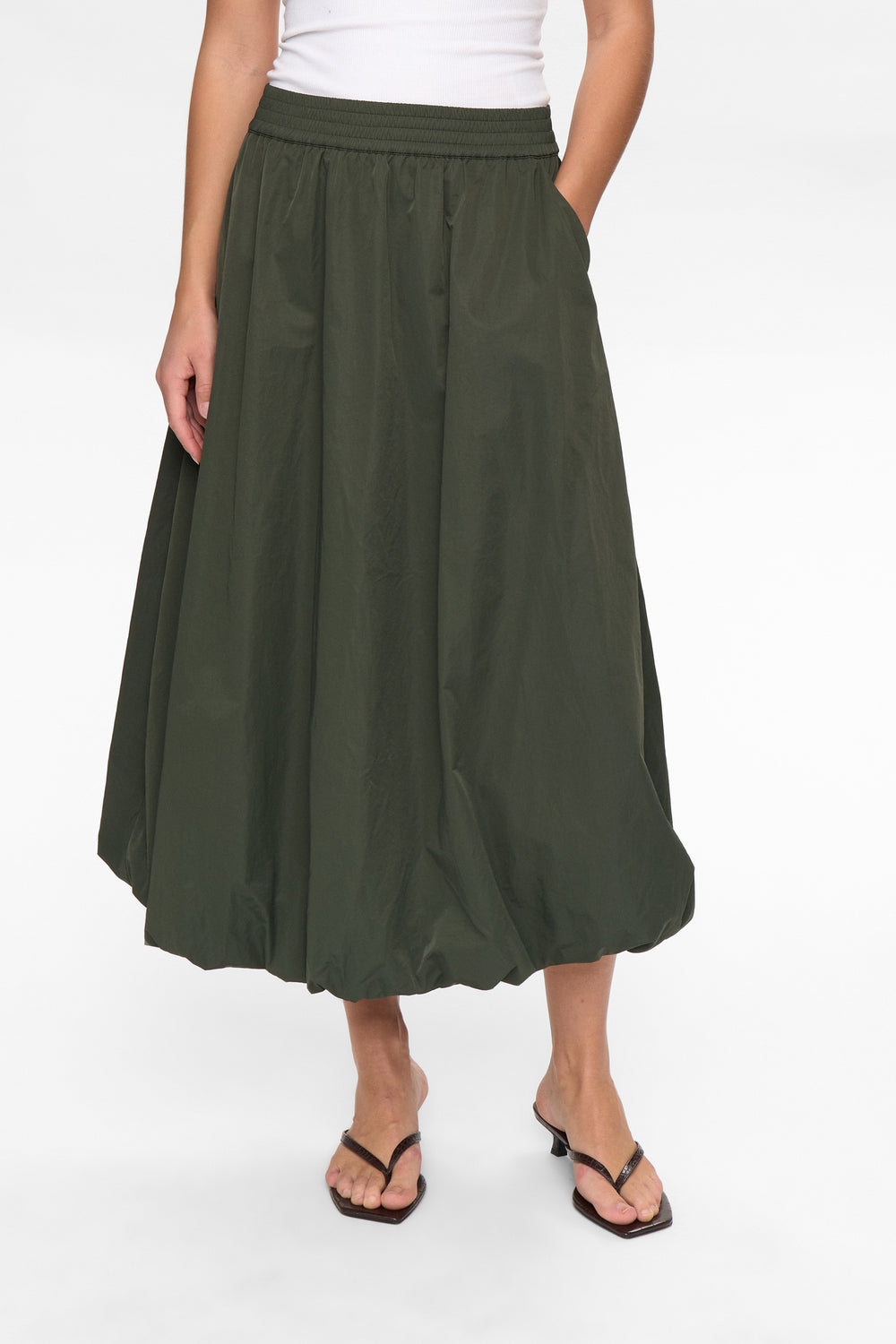 Green skirt worn by a person on a white background